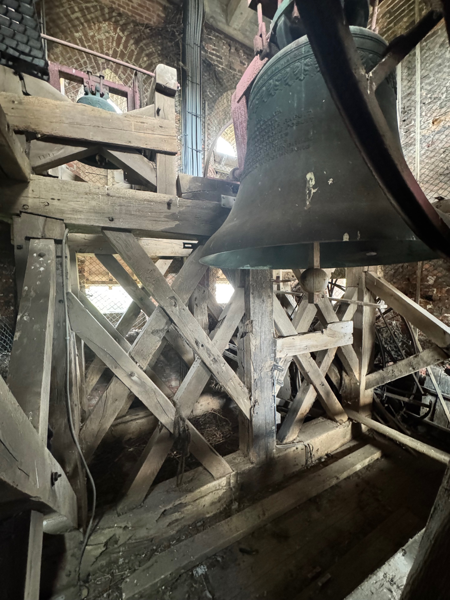 Houten draagstructuur en klok in een historische toren